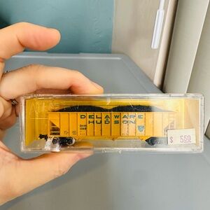 Atlas N Scale 90-ton 3-bay hopper model train car with a load.